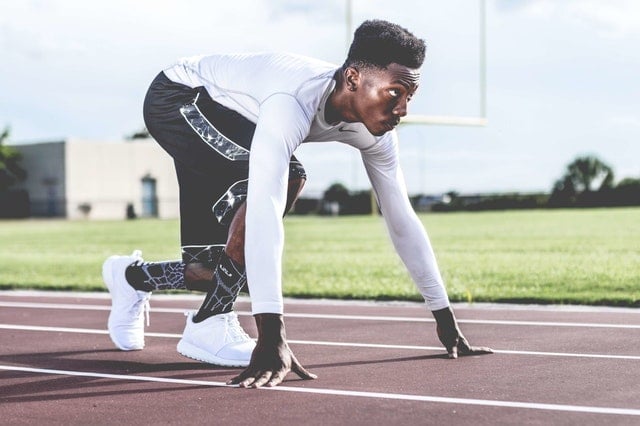 Man on running track in start position